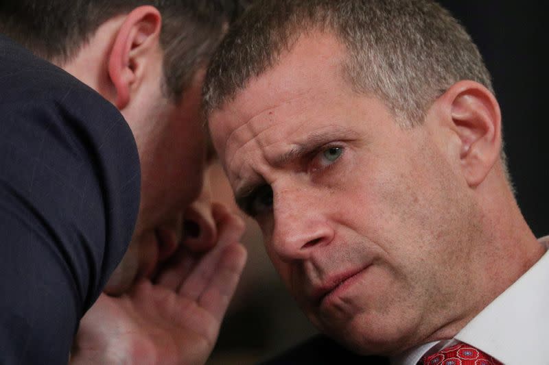 An aide whispers to Republican staff counsel Castor during a House Judiciary Committee hearing in Washington