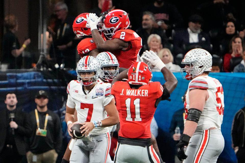 Dec 31, 2022; Atlanta, Georgia, USA; Georgia Bulldogs defensive lineman Mykel Williams (13) and linebacker Smael Mondon Jr. (2) celebrate a sack of Ohio State Buckeyes quarterback C.J. Stroud (7) during the first half of the Peach Bowl in the College Football Playoff semifinal at Mercedes-Benz Stadium. Mandatory Credit: Adam Cairns-The Columbus Dispatch