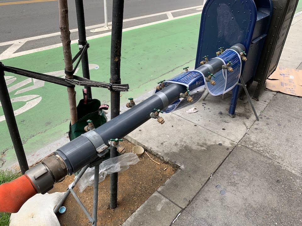 A water manifold with drinking water taps, attached to a fire hydrant at Polk and Turk.