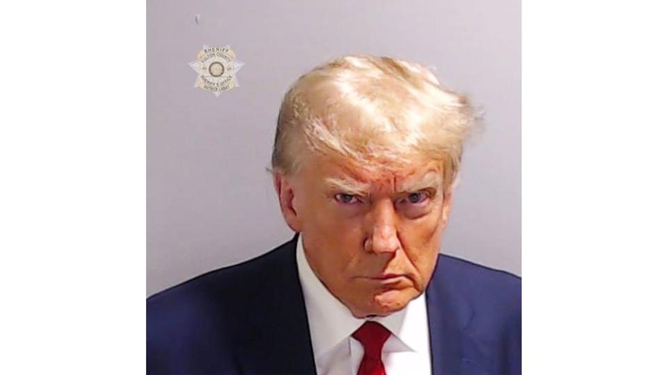 A photo including the mugshot of Former U.S President Donald Trump