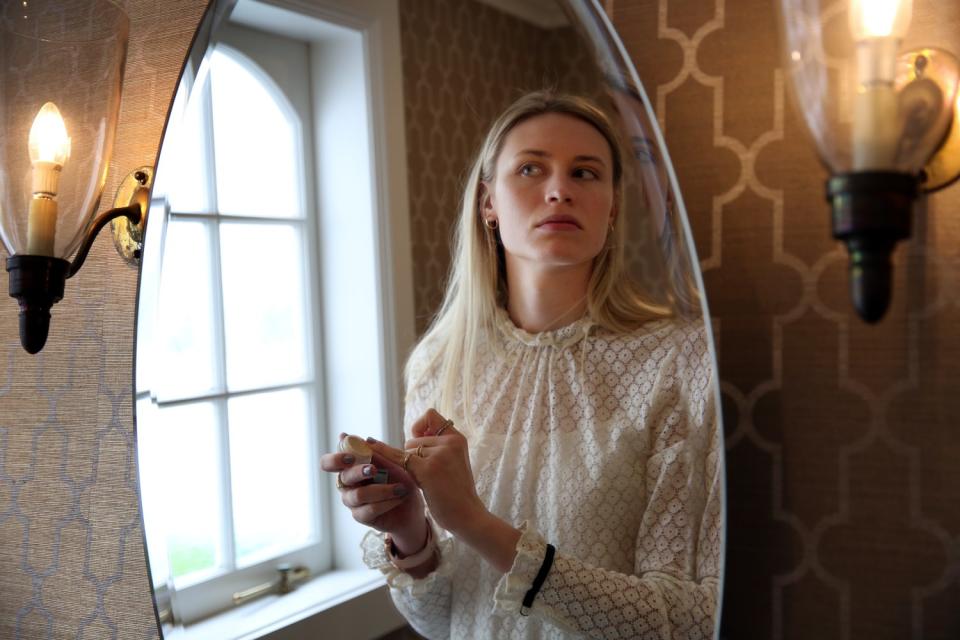 Hayley Hodson puts on makeup in her parents' home.