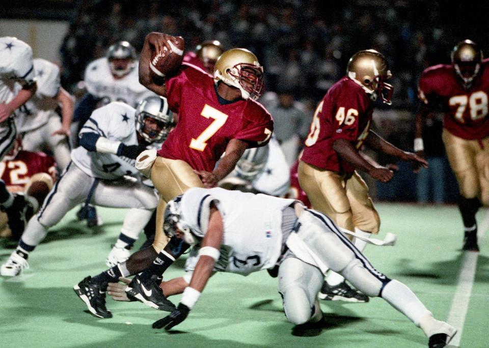 Murfreesboro Riverdale High quarterback Eric Locke (7) gets hit by Knoxville Farragut High defender Marty Beidleman during the TSSAA Class 5A State semifinal action at Middle Tennessee State University in 1995.