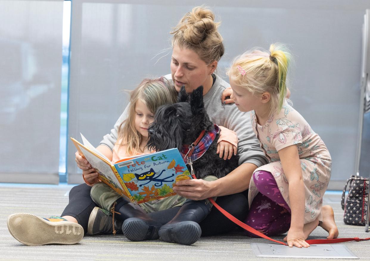 Karly, 4, along with her sister Morgan, 7, and mother Clarissa Pantzer, read to Gibson the Scottish terrier at the Stark Library Jackson Branch's Pups and Pages program.