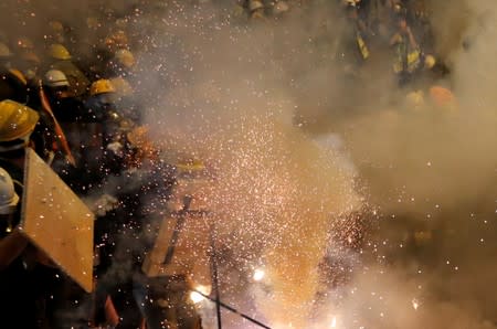 An anti-extradition demonstrators have tear gas fired at them while they clash with riot police, after a march to call for democratic reforms, in Hong Kong