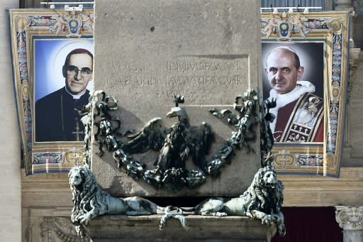 Tapestries of Roman Catholic Archbishop Oscar Romero (l) and Pope Paul VI hang from a balcony of St Peter's Basilica at the Vatican