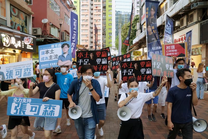 FILE PHOTO: Sam Cheung Ho-sum and Wong Ji-yuet march on a street to campaign for the primary election in Hong Kong