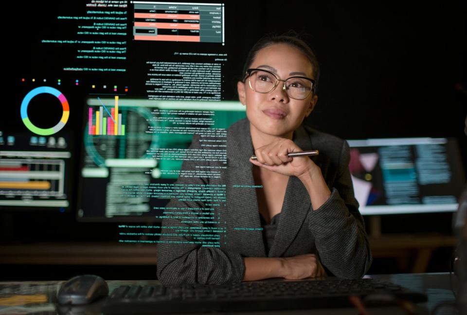 A person studying a transparent display of various charts and graphs.