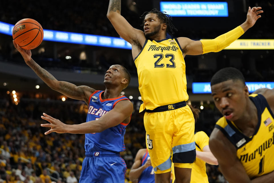 DePaul's Umoja Gibson, left, shoots against Marquette's David Joplin (23) and Kam Jones (1) during the second half of an NCAA college basketball game Saturday, Feb. 25, 2023, in Milwaukee. (AP Photo/Aaron Gash)