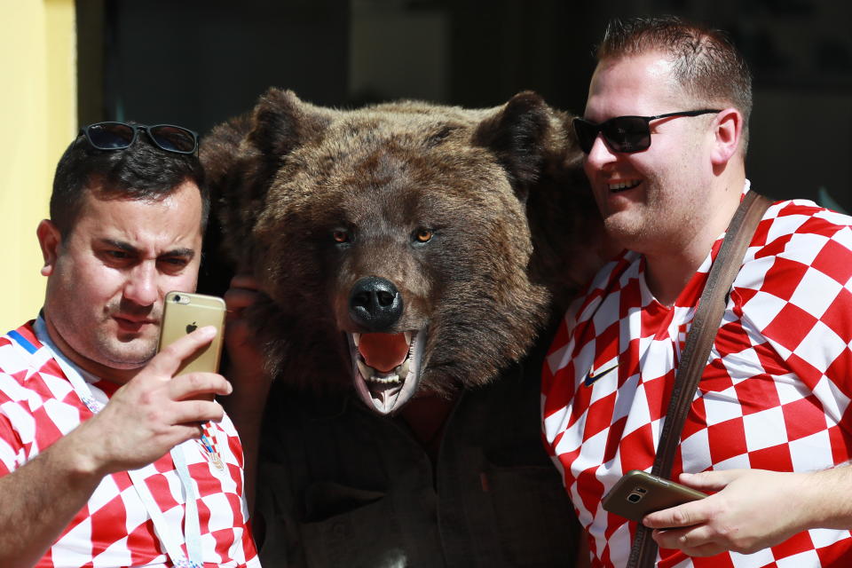 <p>Croatian football fans pose for a picture with a bear figure in a street during the 2018 FIFA World Cup. Vladimir Smirnov/TASS (Photo by Vladimir Smirnov\TASS via Getty Images) </p>