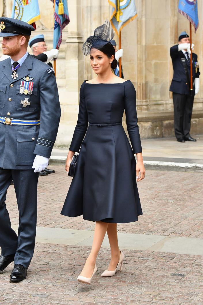 Meghan Markle walking with Prince Harry in a black dress