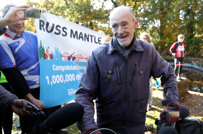 82 year old cyclist Russ Mantle celebrates after cycling his millionth mile following a ride in Mytchett, near Aldershot