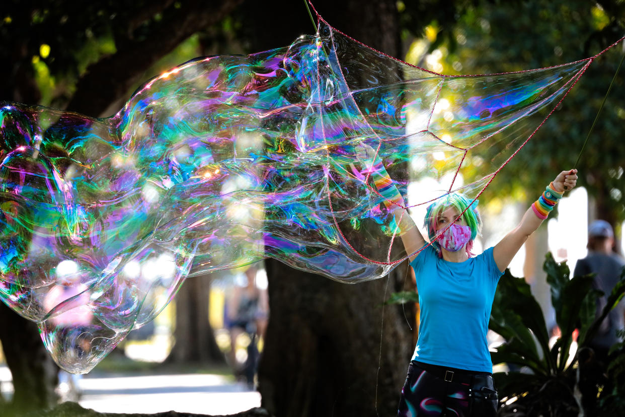 A woman plays with giant soap bubbles on August 15, 2021 in Singapore. (Photo by Suhaimi Abdullah/NurPhoto via Getty Images)