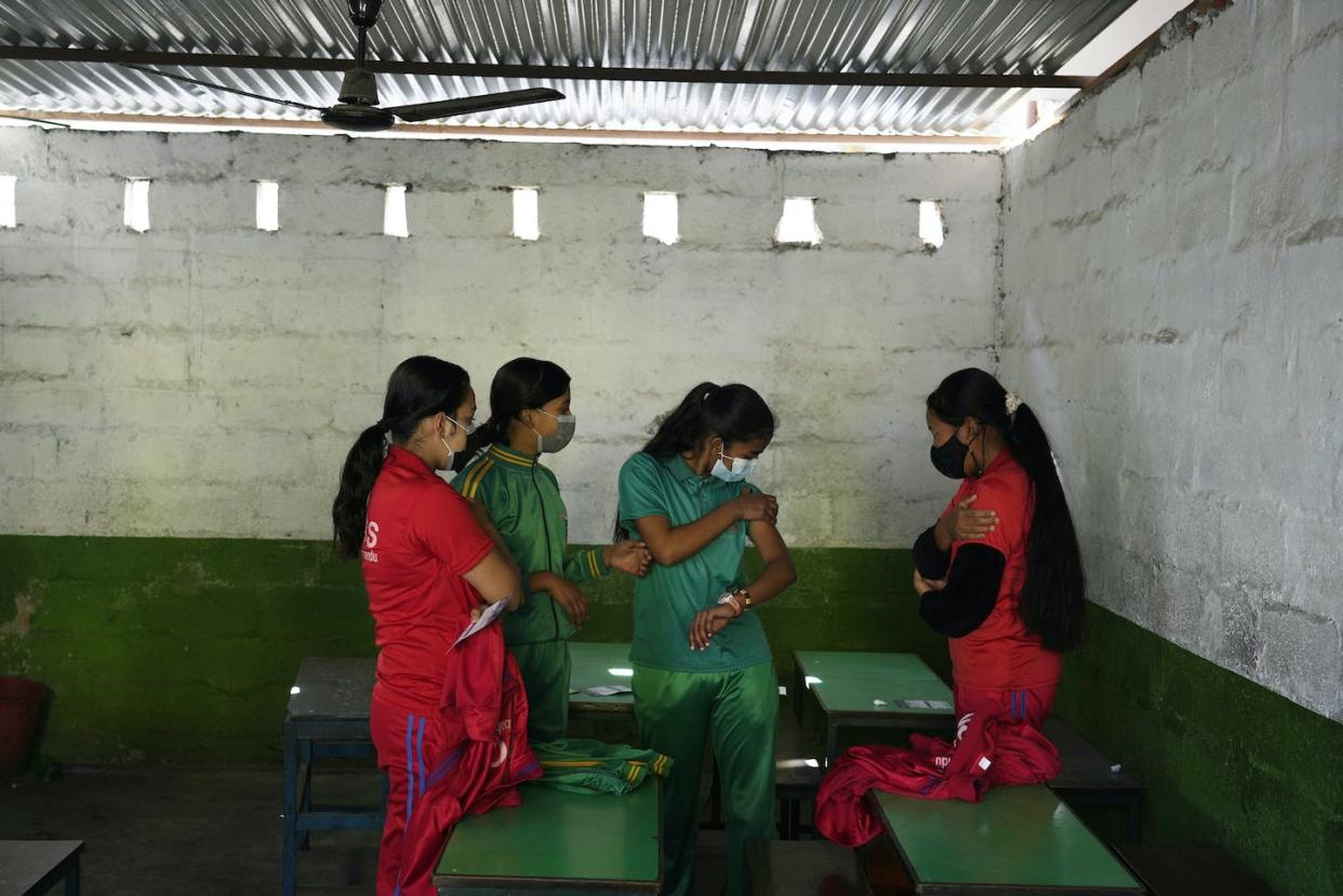 Nepalese girls rest for observation after receiving the Moderna vaccine for COVID-19 in Kathmandu, Nepal. (AP Photo/Niranjan Shrestha)