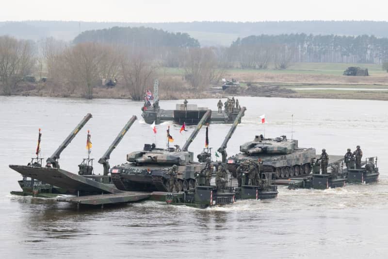 Bundeswehr soldiers (front) take part in a joint military exercise with soldiers from several NATO countries on the Vistula. Around 20,000 soldiers from nine NATO countries are taking part in the exercise called Dragon 24 on Poland's longest river. The crossing of the Vistula is a test of cooperation between the armed forces on land, at sea, in the air and in cyberspace. Sebastian Kahnert/dpa