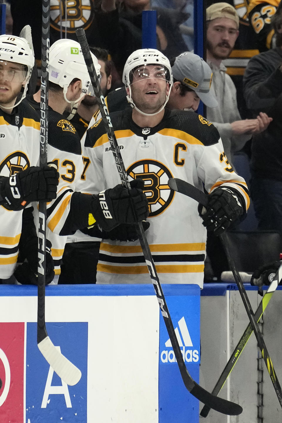 Boston Bruins center Patrice Bergeron (37) smiles after assisting on a goal by left wing Brad Marchand against the Tampa Bay Lightning during the second period of an NHL hockey game Monday, Nov. 21, 2022, in Tampa, Fla. (AP Photo/Chris O'Meara)