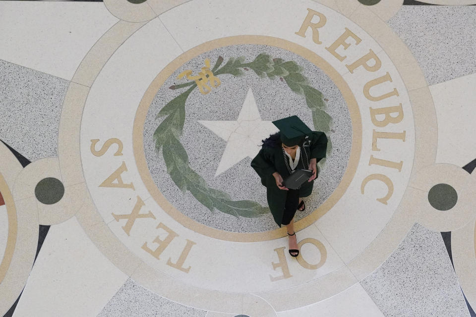 A graduate poses for family photos in the rotunda at the State Capitol, Tuesday, June 1, 2021, in Austin, Texas. The Texas Legislature closed out its regular session Monday, but are expected to return for a special session after Texas Democrats blocked one of the nation's most restrictive new voting laws with a walkout. (AP Photo/Eric Gay)