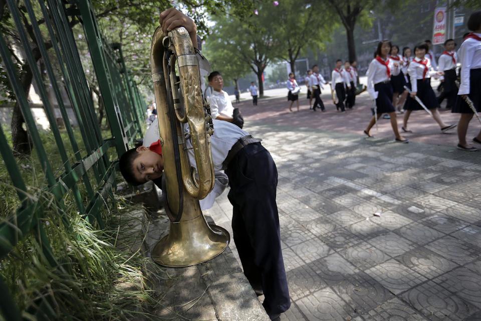 A North Korean student cleans his tuba ahead of a parade to celebrate the anniversary of the Korean war armistice agreement, Sunday, July 27, 2014, in Pyongyang, North Korea. North Koreans gathered at Kim Il Sung Square as part of celebrations for the 61st anniversary of the armistice that ended the Korean War.(AP Photo/Wong Maye-E)