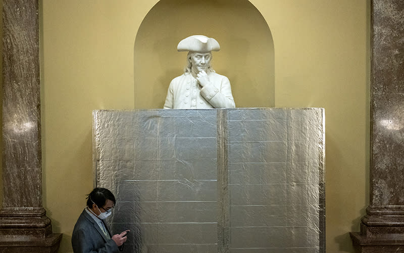 A statue of Benjamin Franklin is seen behind a screen near the Senate Chamber on April 27 as restoration work begins around the Chamber. <em>Greg Nash</em>