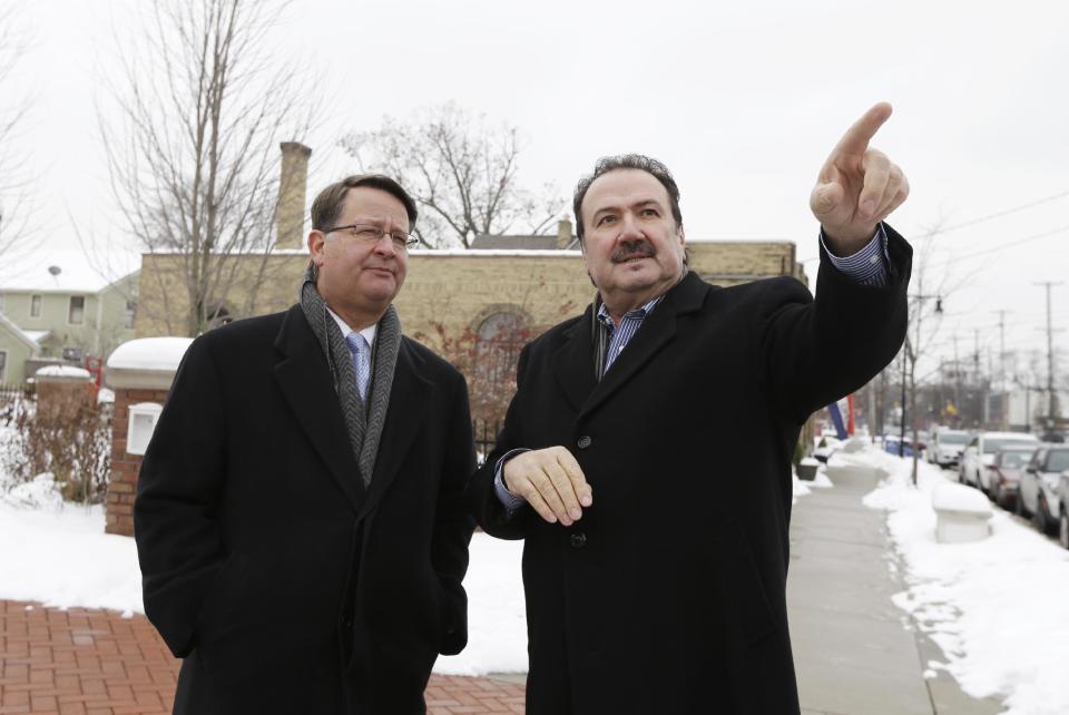 In this Dec. 19, 2013 photo Michigan Democratic Senate candidate Gary Peters, left, talks with commercial developer Guy Bazzani during a tour of the Wealthy Street Business District in Grand Rapids, Mich., during a campaign swing through the conservative western part of the state. In a state where Democratic voter participation has dropped more sharply than Republican in recent midterm contests, Peters is going to a lot of places where his party’s candidates normally don’t go, seeking support from people who don’t normally back Democrats and saying things they might not expect to hear from a Democrat. (AP Photo/Carlos Osorio)