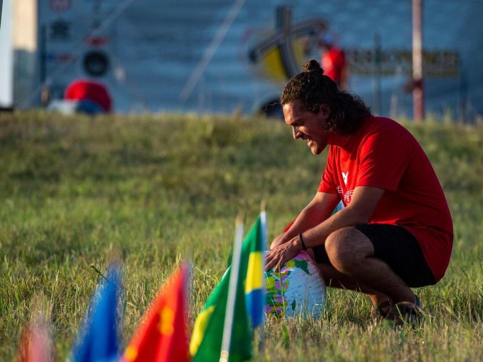 Nick Ponce from Idaho, prays for nations and countries around the world after the Prayer at the Heart of America event in Lebanon, Kansas, Friday, July 22, 2021. Ponce walked along rows of flags while he prayed.