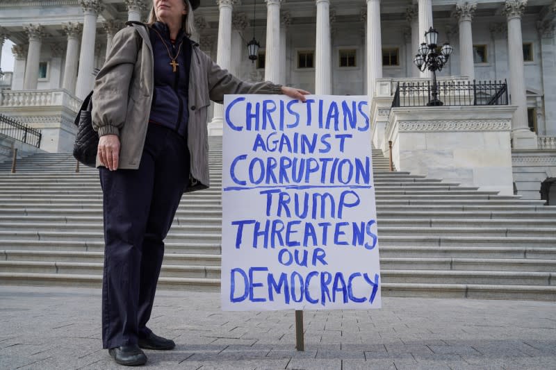 A demonstrator gathers on Capitol Hill on day three of the impeachment trial of President Trump in Washington