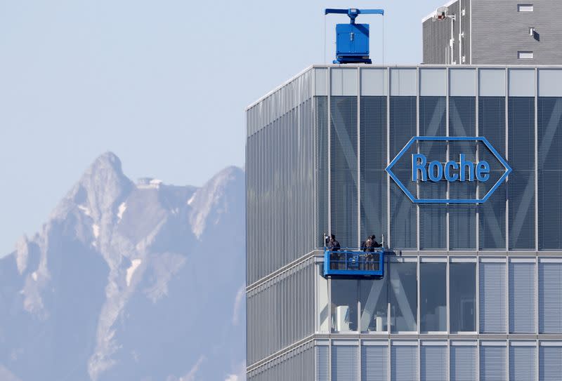 FILE PHOTO: Workers clean windows of a building of Roche in Rotkreuz