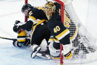 Boston Bruins goaltender Tuukka Rask (40) gets jammed as his defenseman Jeremy Lauzon (55) and Pittsburgh Penguins' Jason Zucker, left, slide into the net during the second period of an NHL hockey game, Tuesday, Jan. 26, 2021, in Boston. (AP Photo/Charles Krupa)