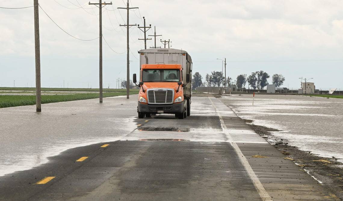 A truck drives through a flooded road in Kings County south of Hanford on Thursday, March 23, 2023.