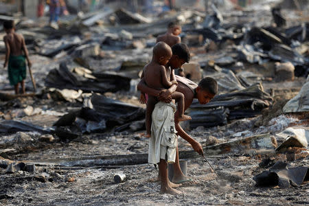 Boys search for useful items among the ashes of burnt houses after fire destroyed shelters at a camp for internally displaced Rohingya Muslims in the western Rakhine State near Sittwe, Myanmar May 3, 2016. REUTERS/Soe Zeya Tun