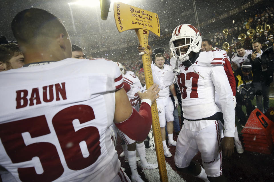 Wisconsin wide receiver Quintez Cephus (87) hands Paul Bunyan's Axe to teammate linebacker Zack Baun (56) after Wisconsin beat Minnesota 38-17 in an NCAA college football game Saturday, Nov. 30, 2019, in Minneapolis. (AP Photo/Stacy Bengs)