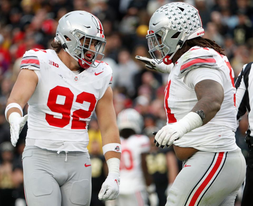Ohio State Buckeyes defensive end Caden Curry (92) and Ohio State Buckeyes defensive tackle Tyleik Williams (91) celebrate a defensive stop during the NCAA football game against the Purdue Boilermakers, Saturday, Oct. 14, 2023, at Ross-Ade Stadium in West Lafayette, Ind. Ohio State Buckeyes won 41-7.