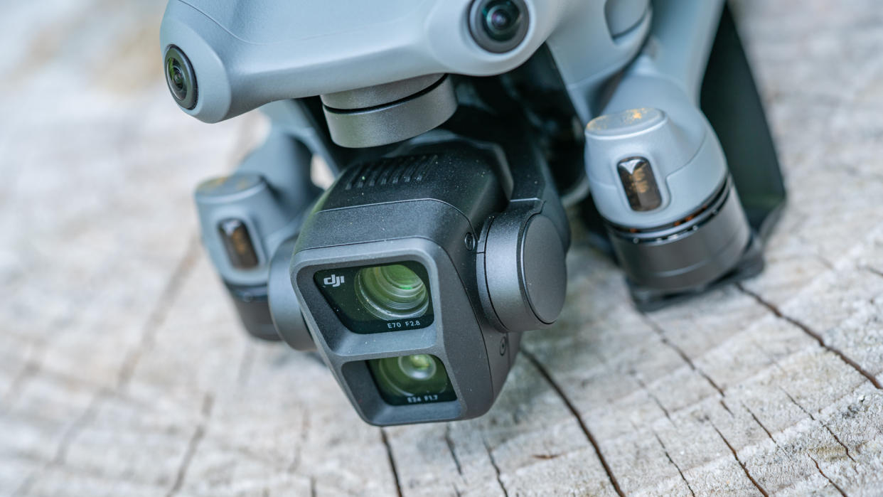  DJI Air 3 drone on a tree stump next to remote controller 