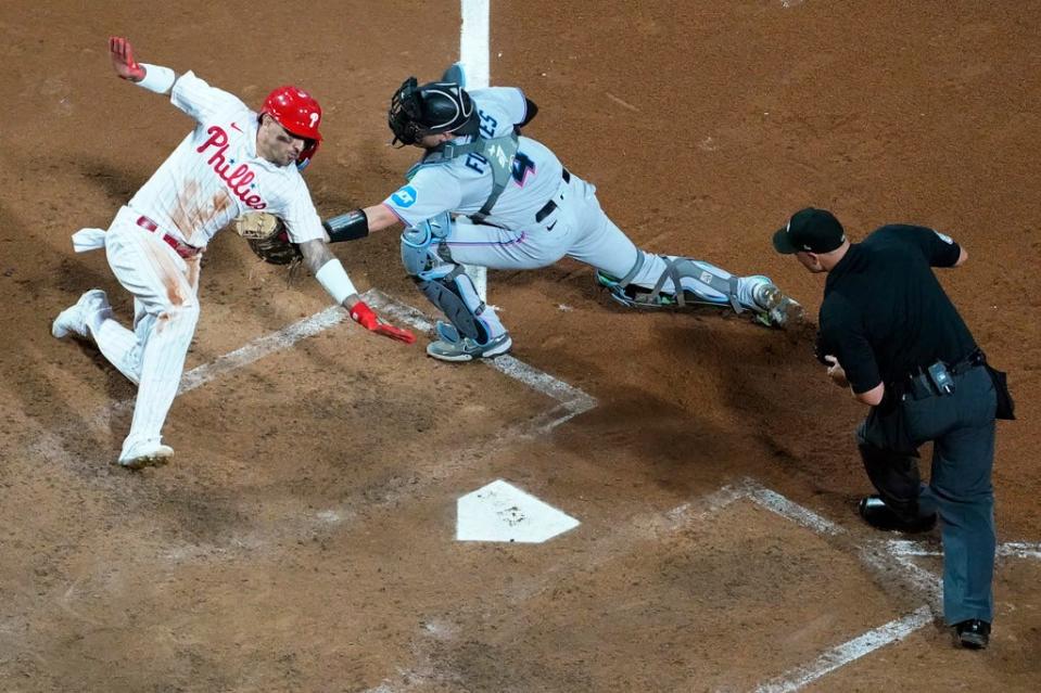 Philadelphia Phillies' Nick Castellanos, left, is tagged out by Miami Marlins catcher Nick Fortes after trying to score on an RBI-single by Bryson Stott during the fourth inning of Game 1 in an NL wild-card baseball playoff series, Tuesday, Oct. 3, 2023, in Philadelphia. (AP Photo/Matt Slocum)