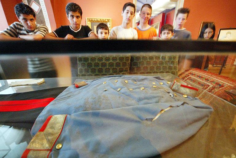 Visitors look at the uniform Archduke Franz Ferdinand wore when he was assassinated by a Serb nationalist student Gavrilo Princip, 90 years after the Archduke's assassination, at a military history museum in Vienna, on June 28, 2004