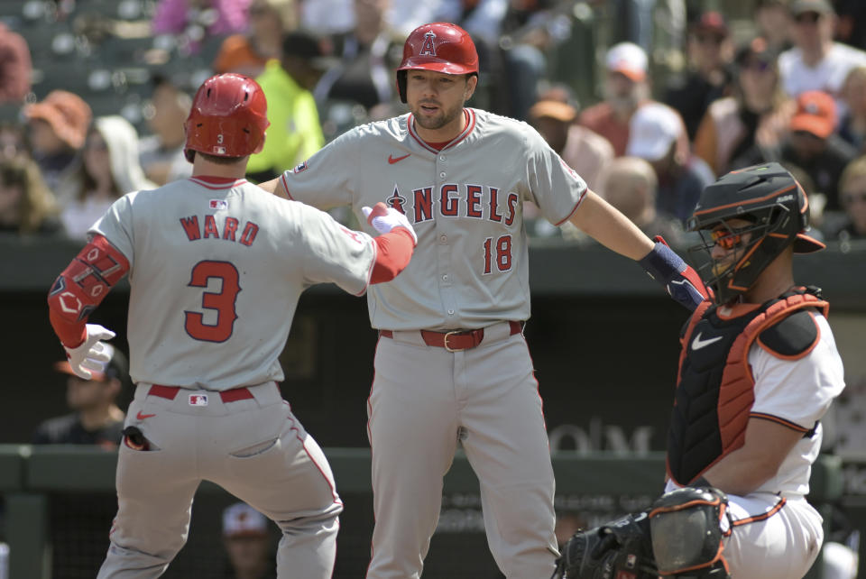 Los Angeles Angels' Nolan Schanuel (18) high-fives teammate Taylor Ward after both scored on a two-run home run by Ward against the Baltimore Orioles during the first inning of a baseball game, Sunday, March 31, 2024, in Baltimore. (AP Photo/Steve Ruark)