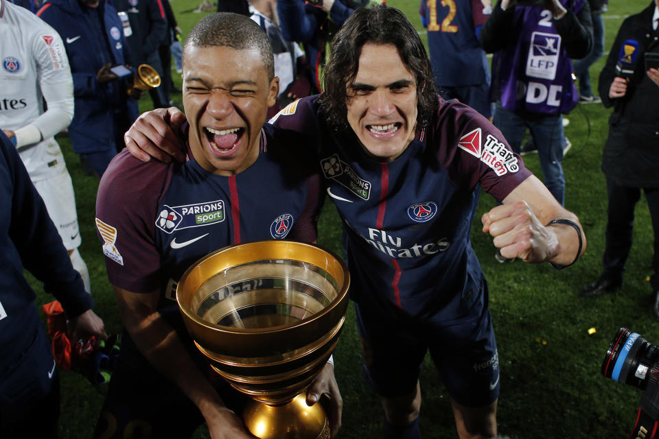 ARCHIVO - Edinson Cavani (derecha) y Kylian Mbappé con el trofeo de campeones de la la Copa de la Liga de Francia tras vencer a Mónaco, el sábado 31 de marzo de 2018, en Burdeos. (AP Foto/Thibault Camus)