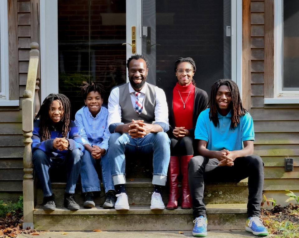 Stephen Chukumba sits with his three sons and daughter outside their Trenton, N.J. home.