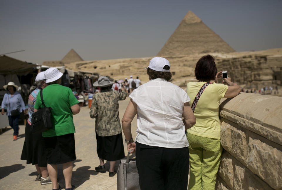 Tourists visit the Giza Pyramids near Cairo, Egypt, Tuesday, May 21, 2019, two days after a tour bus struck an improvised explosive device near the site, wounding more than a dozen foreign tourists. (AP Photo/Maya Alleruzzo)