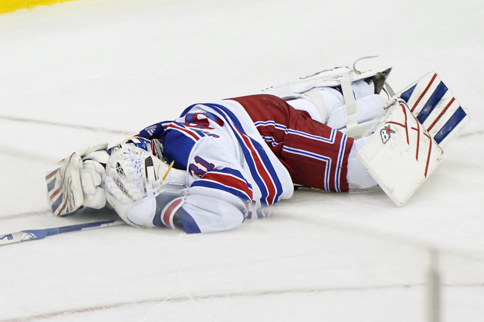 New York Rangers goaltender Igor Shesterkin (31) lies on the ice after suffering an injury during the third period of an NHL hockey game against the New Jersey Devils, Thursday, March 4, 2021, in Newark, N.J. (AP Photo/Kathy Willens)