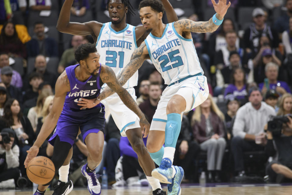 Charlotte Hornets center Nathan Mensah (31) and forward P.J. Washington (25) guard Sacramento Kings guard Malik Monk during the first quarter of an NBA basketball game in Sacramento, Calif., Tuesday, Jan. 2, 2024. (AP Photo/Randall Benton)