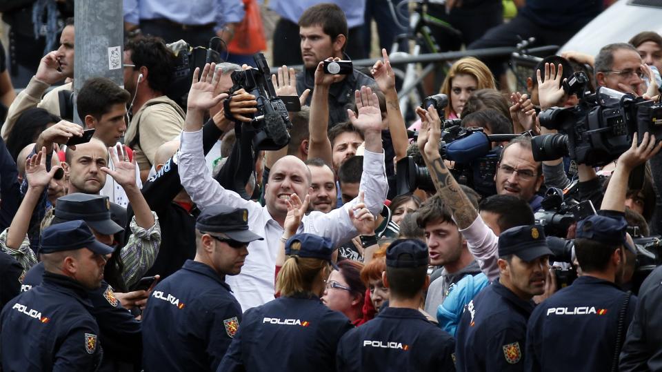 Spanish police block animal rights activists protesting outside the apartment building of the Spanish nurse who contracted Ebola in Alcorcon, outside Madrid, October 8, 2014. Madrid regional authorities said they would euthanize the nurse's dog Excalibur to avoid possible contagion, sparking an outcry by animal rights activists to save the dog. REUTERS/Susana Vera (SPAIN - Tags: HEALTH SOCIETY ANIMALS CIVIL UNREST)