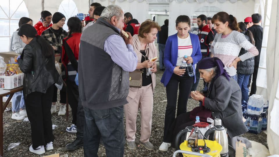 Refugees eat food in a tent of the Armenian Red Cross registration centre, near the border town of Kornidzor, on September 26, 2023. - Alain Jocard/AFP/Getty Images