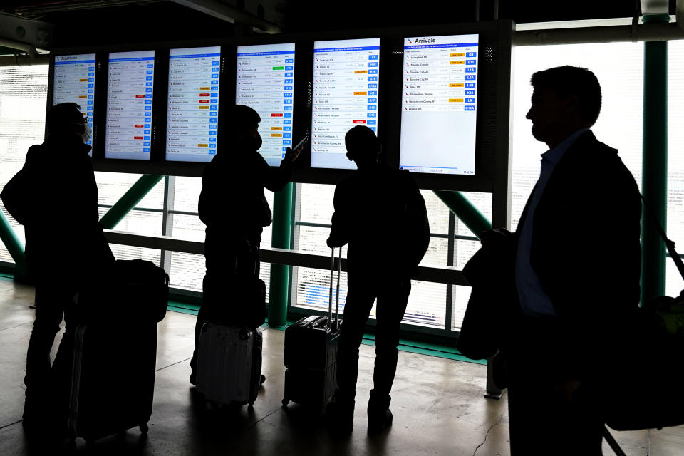 Travelers check American Airlines flight information screens for their flight status at O'Hare International Airport in Chicago, Wednesday, Feb. 22, 2023. More than 100 flights are canceled as portions of the greater Chicago area could see freezing rain and ice, while others see heavy rain. (AP photo/Nam Y. Huh)