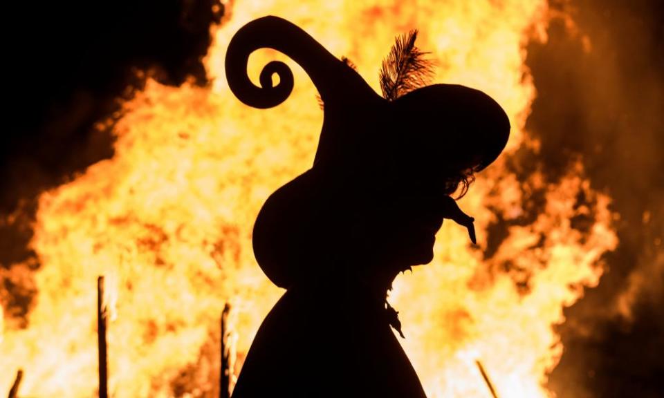 A woman dressed as a witch walks in front of a giant fire during the Walpurgis night celebrations in Erfurt, central Germany.