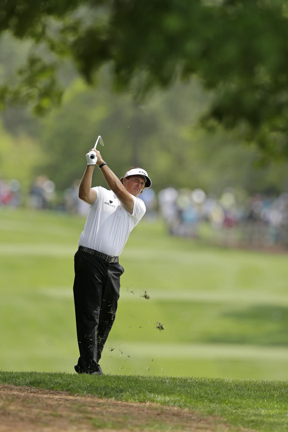 Phil Mickelson watches his approach shot on the fourth hole during the first round of the Wells Fargo Championship golf tournament in Charlotte, N.C., Thursday, May 1, 2014. (AP Photo/Chuck Burton)