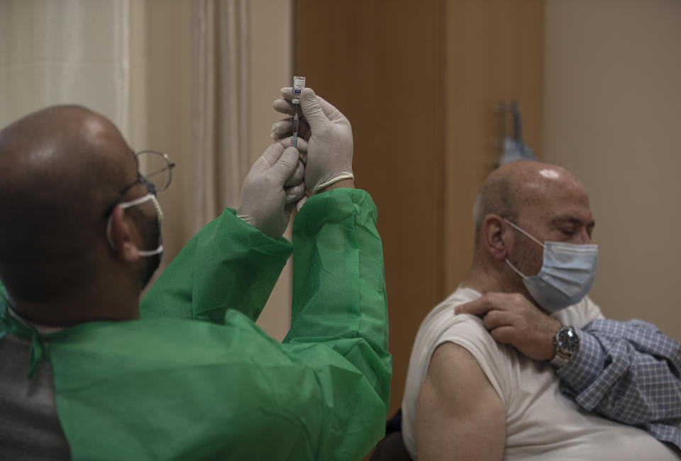 A Palestinian medic prepares to give a shot of the Russian-made Sputnik V coronavirus vaccine, at an UNRWA clinic in Gaza City, Wednesday, March 17, 2021. The Palestinian Authority says it will receive 62,000 coronavirus vaccine doses through a World Health Organization partnership designed to help poor countries. (AP Photo/Khalil Hamra)