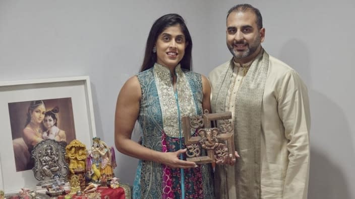 Sheetal Deo (left) and her husband, Sanmeet Deo, hold a Hindu swastika symbol in their New York home. Hindus, Buddhists and Native Americans are trying to rehabilitate the swastika. (Photo: Andres Kudacki/AP)