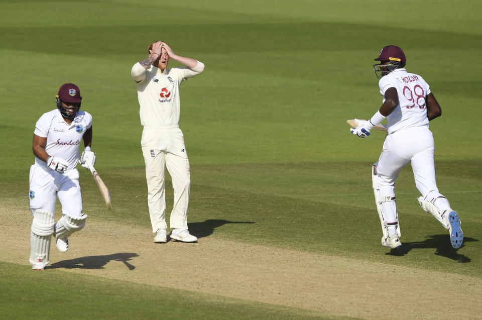 England captain Ben Stokes, center, reacts as West Indies captain Jason Holder, right, and John Campbell, left, take a run during the fifth day of the first cricket Test match between England and West Indies, at the Ageas Bowl in Southampton, England, Sunday, July 12, 2020. (Mike Hewitt/Pool via AP)