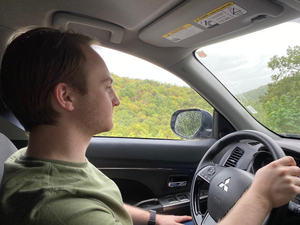 man in green shirt driving outlander along Skyline drive in Shenandoah