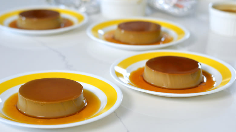 Four custard puddings unmolded onto plates